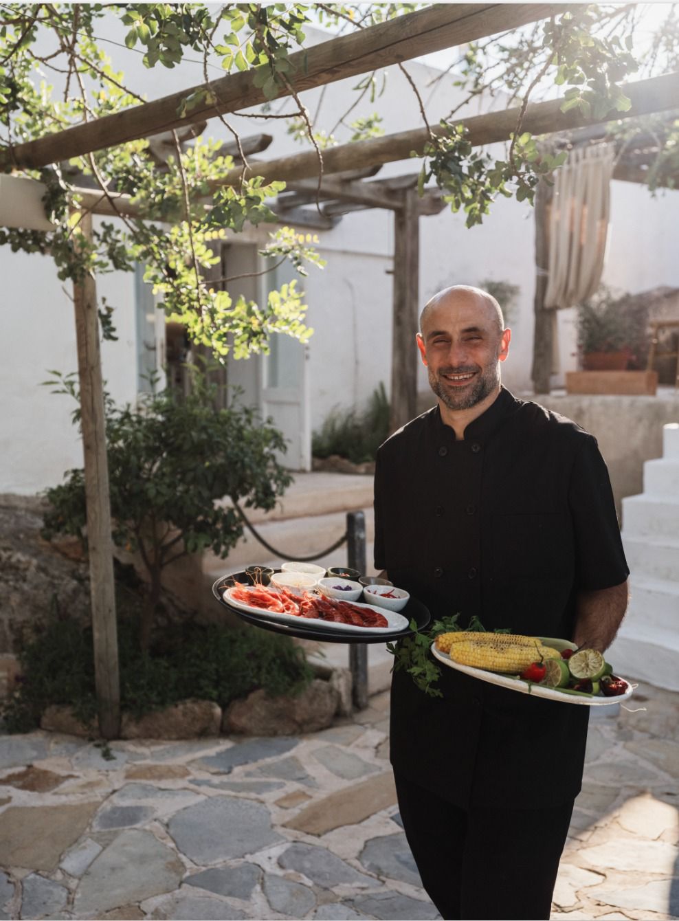 A host carrying plates through the garden courtyard